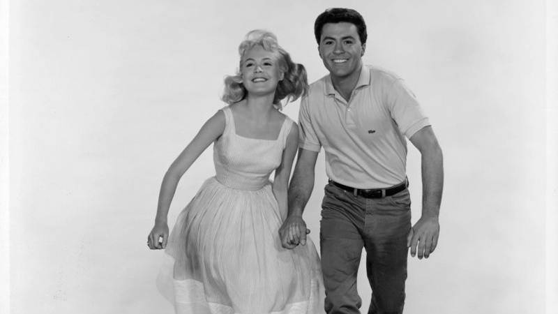 Sandra Dee and James Darren running on the sand in publicity portrait for the film 'Gidget', 1959.