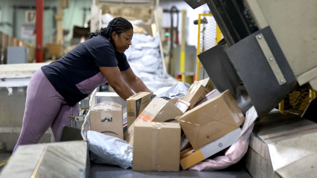 A person processing packages at a USPS facility.